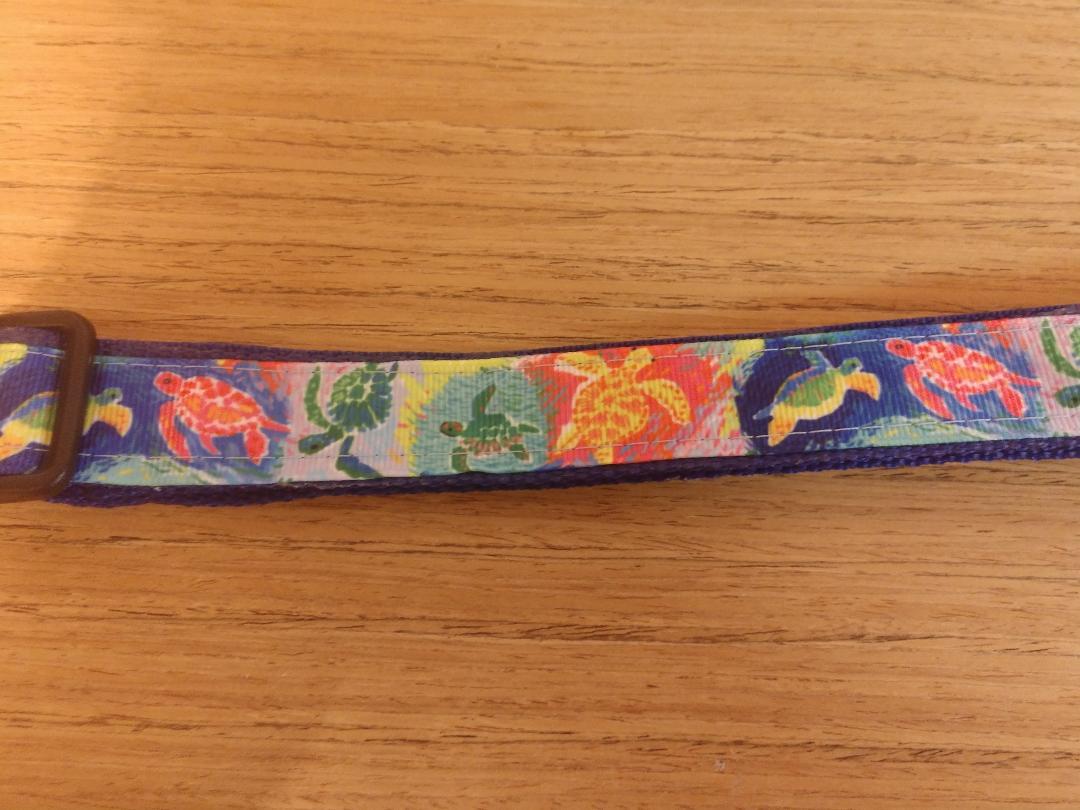 A small dog collar featuring a vibrant sea turtle design, measuring 12-16 inches in neck size, made with durable materials.